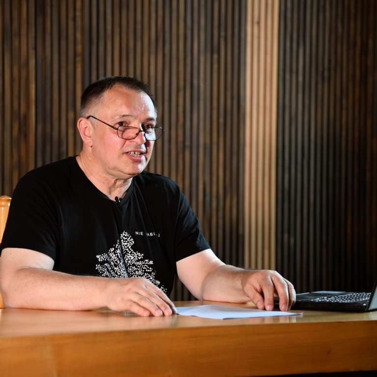 Wojciech Birek siedzi przed laptopem w czasie wykładu w sali WDK w Rzeszowie